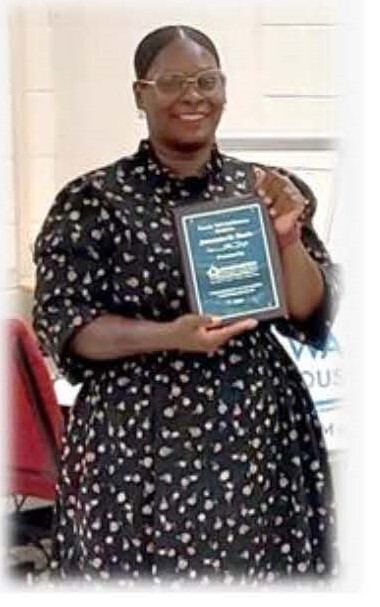 Ms. Davis holding her certificate plaque. 