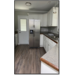 Kitchen view of counters, sink, and refrigerator.