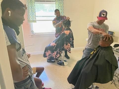 Boys cutting hair in a room.