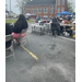 Folks sitting at tables in a parking lot.