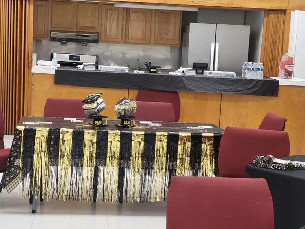 A decorated table with graduation decorations and streamers along the sides. 