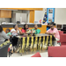 A family is sitting at a decorated table with streamers and graduation centerpieces on it. 