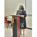 A woman is speaking behind a podium. 