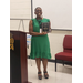 A young woman is smiling as she holds an award plaque. 