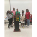 A family standing and smiling behind a 2024 graduation decorated podium.