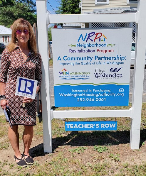 Realtor Alexis Davis with Coldwell Banker Sea Coast Advantage standing next to the NRP sign.