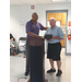 Mr. Davis looking at his award while standing next to another man.