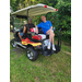 Two gentlemen sitting on the cart resting.