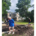 People using shovels in the garden area.