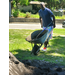 A man with a wheelbarrow and a shovel heading toward a pile of dirt.