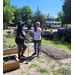 Two ladies standing in the garden area with tools looking around.