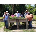 A group of peop-le standing around a raised plant bed.