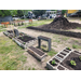 Garden beds with plant in them and a big pile of dirt.