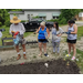 A man working out how to plant an item and standing next to three women.