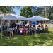 People sitting under a canopy at the ribbon cutting ceremony.