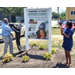 People standing around the community garden sign.