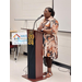 A lady standing at a podium speaking.