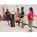 Lady speaking to a woman during the awarding of a plaque.