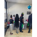 Men and women standing in line looking at the information tables. 