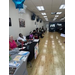 Long view of a room with tables and people waiting for haircuts and showing information about their organization.