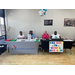 Two tables showing information and balloons with people sitting behind them. 