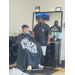 Teen sitting and getting his hair cut. 