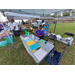 Smiling lady behind a table surrounded by assorted items and people for the National Night Out.