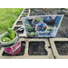 Sign with pictures of Tenylah and Jheannah working their garden spot next to a container with some cucumbers in it.