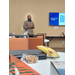 A man in front of the conference room in front of tables and snacks.