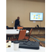 A man sitting on a table next to the smart board with the presentation.