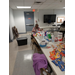 A lady sitting at the end of the snacks and prizes table.