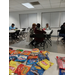 Several tables with people playing bingo in front of a table with snacks.